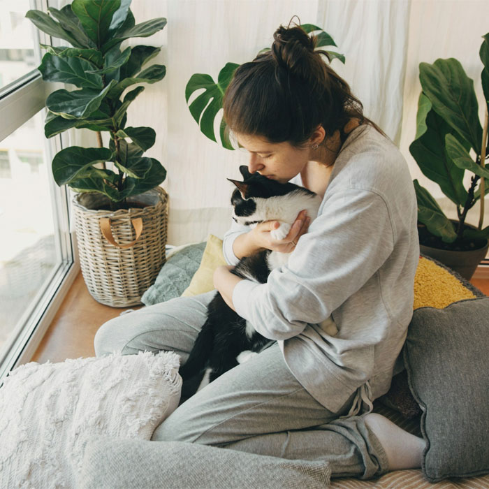 A girl hugging her black and white cat